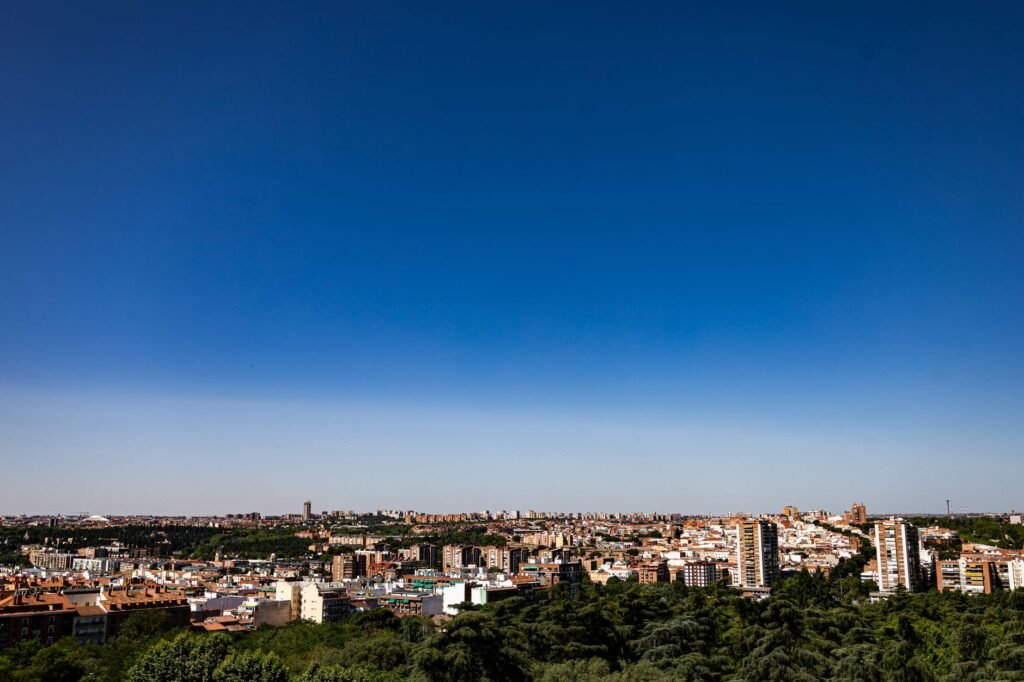 Panorámica de Madrid capital bajo un cielo azul intenso en verano, reflejo del clima extremo que afecta a los áticos de la ciudad