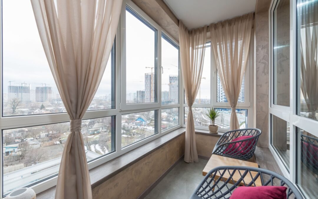 Terraza cerrada con cortinas de cristal en ático de edificio en altura, con vistas a la ciudad. Photo by Pexels.