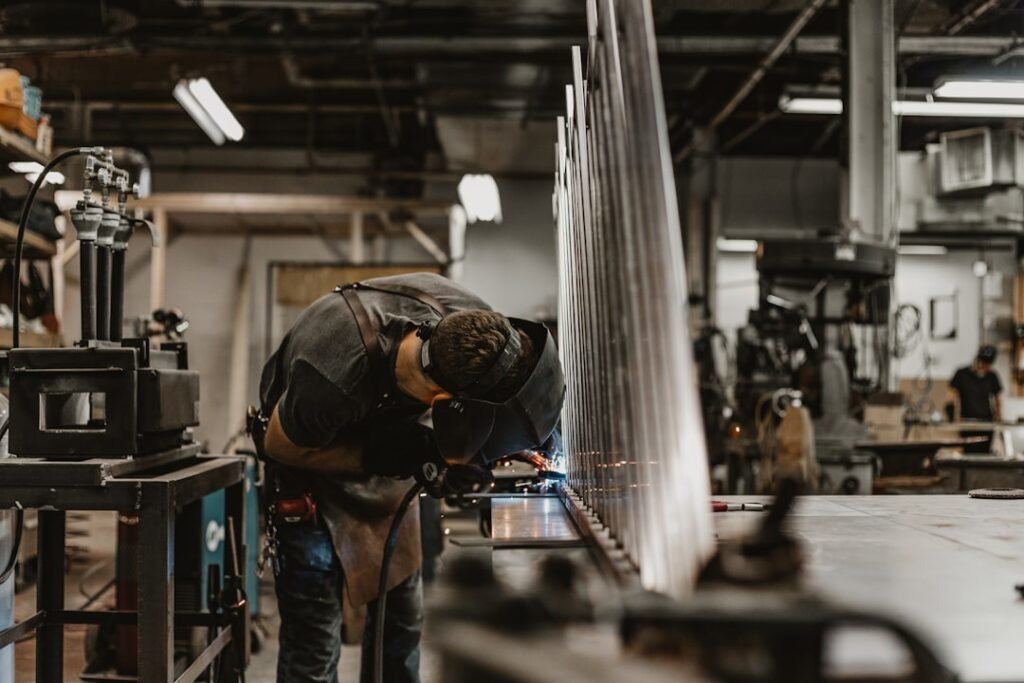Operario trabajando con perfiles de aluminio en taller de fabricación de pérgolas a medida