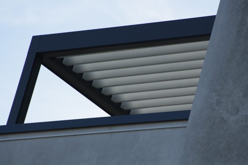 Detalle de lamas de aluminio orientables en pérgola bioclimática con estructura en gris antracita